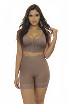 Woman wearing a brown sports bra and shorts set on a white background